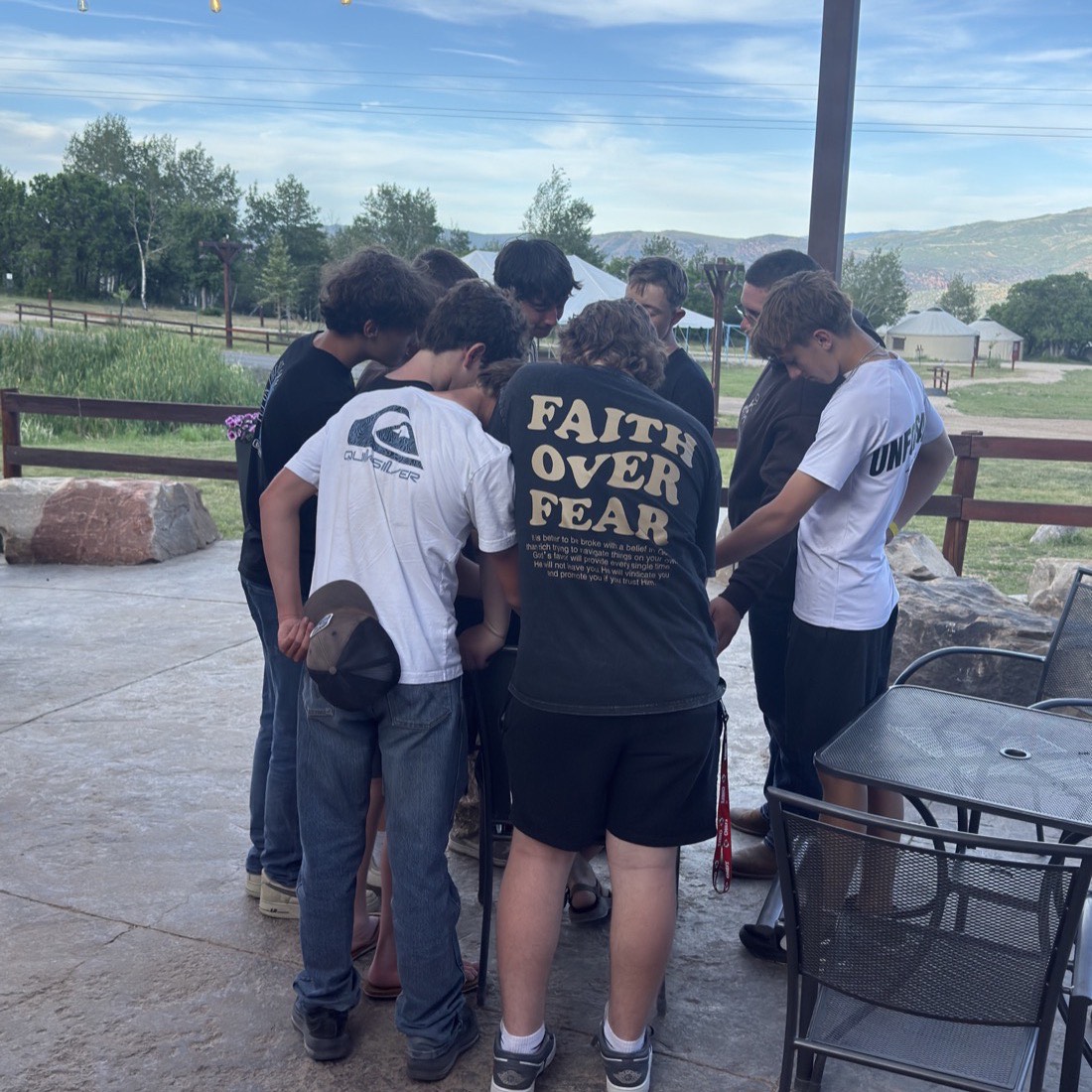 A small group of students huddled together outdoors at MVF Students